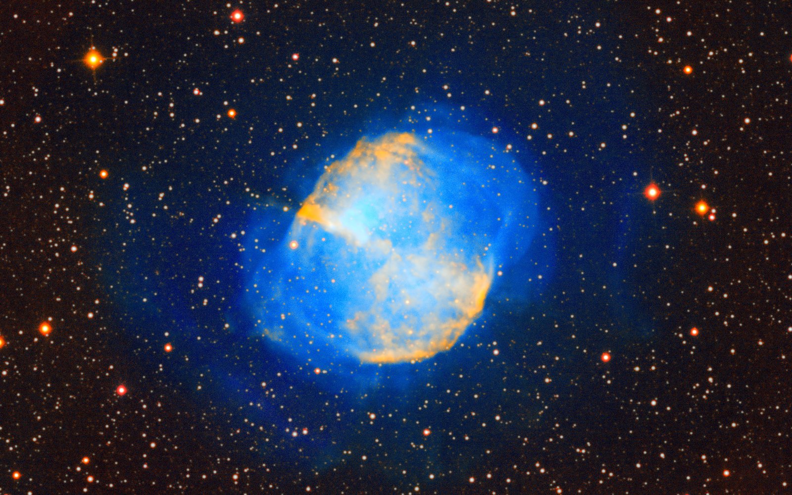 The Dumbbell Nebula: a blue glowing shell with orange lobes